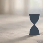 A simple hourglass silhouette against soft light, abstract, no text or numbers