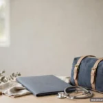 A small travel bag beside a closed folder on a bright desk, journey motif, no text
